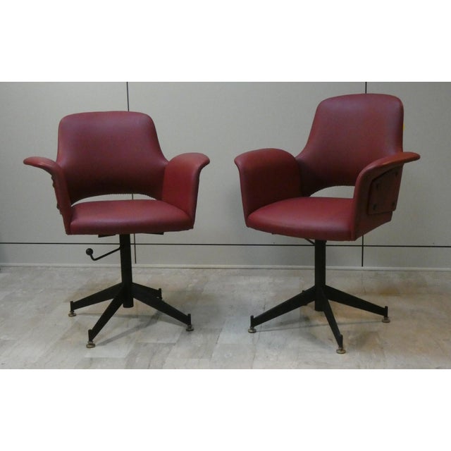Gorgeous 1960s armchairs, fully restored with burgundy red upholstery and brass studs. These chairs feature a delicate...