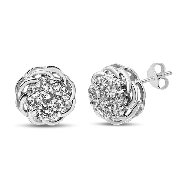 Clusters of brilliant round diamonds nestled within prong settings adorn this pair of openwork floral stud earrings for...