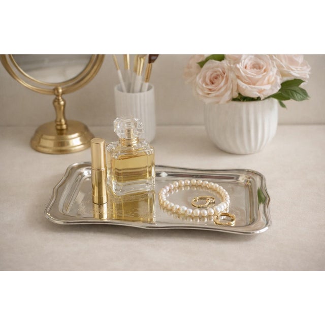 A beautifully detailed vintage Sheridan silverplate tray featuring ornate mid‑century scroll engraving and a softly...