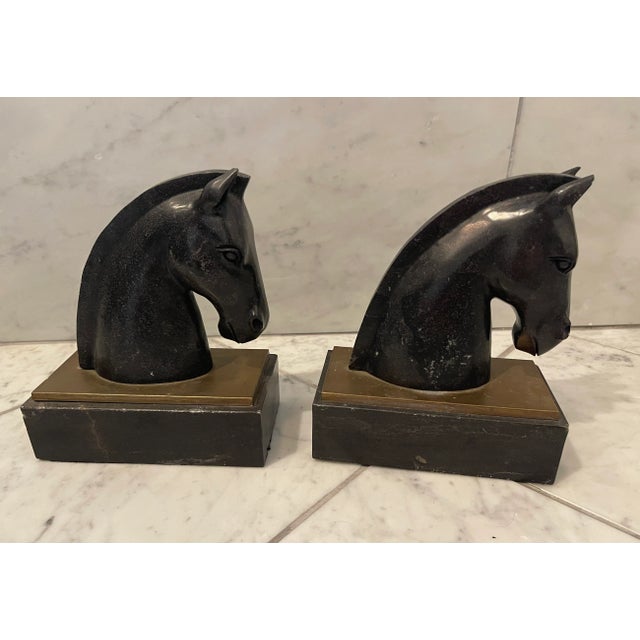 A substantial pair of horse head books, in black marble and brass. Beautiful detailing. Works in a variety of interiors.