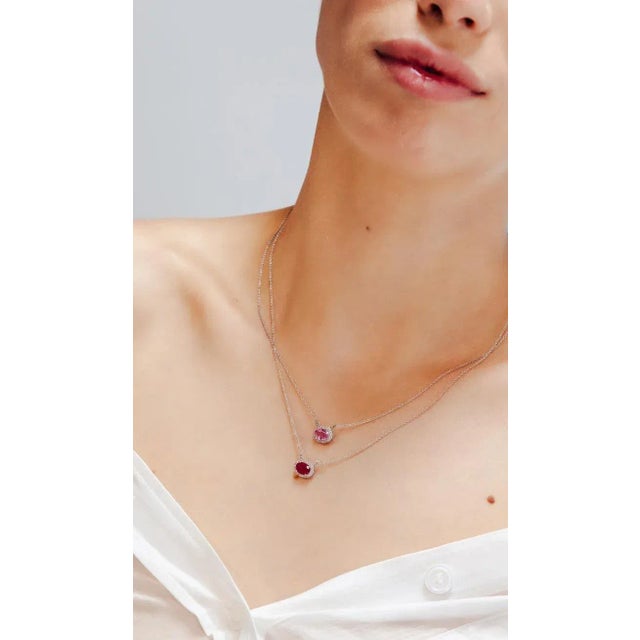 This is part of Chairish’s Fine Jewelry assortment. Oval Ruby and Diamond Halo Pendant Necklace in 14K Gold studded with...