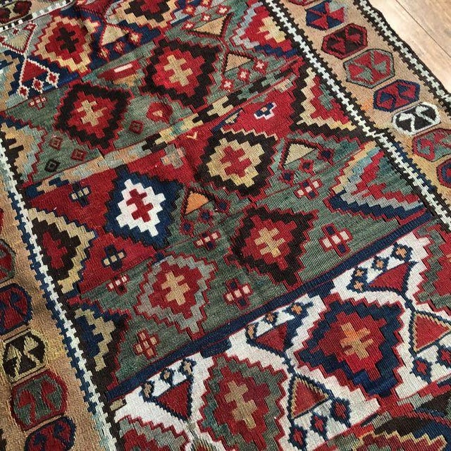 A rare and character-rich antique kilim, handwoven over a century ago, this piece is a beautiful expression of tribal...