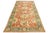 Handmade Persian Sultanabad wool rug featuring a coral orange field and multicolored floral accents throughout. This rug...
