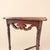 A half-moon console with the kind of quiet formality that anchors an entryway. The apron is a pierced fretwork band of...