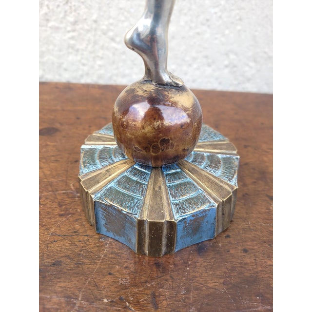 Large silvered and patinated bronze sculpture representing a dancer balancing on a ball, and juggling balls. These balls...