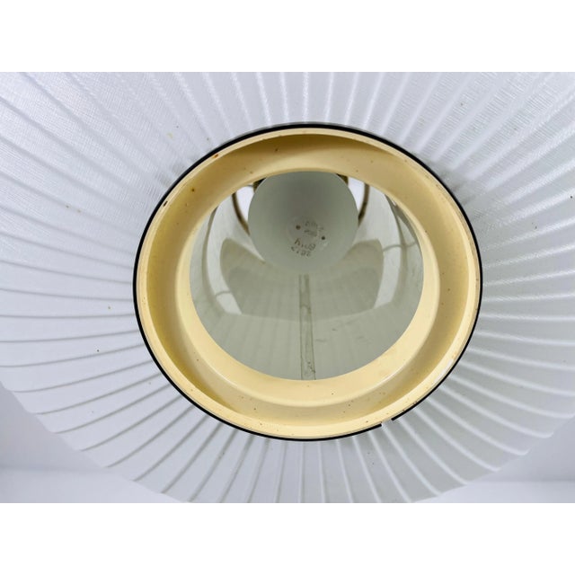 Presenting a saucer-shaped pendant lamp from the 1960s, embodying minimalist Italian design. This elegant fixture features...