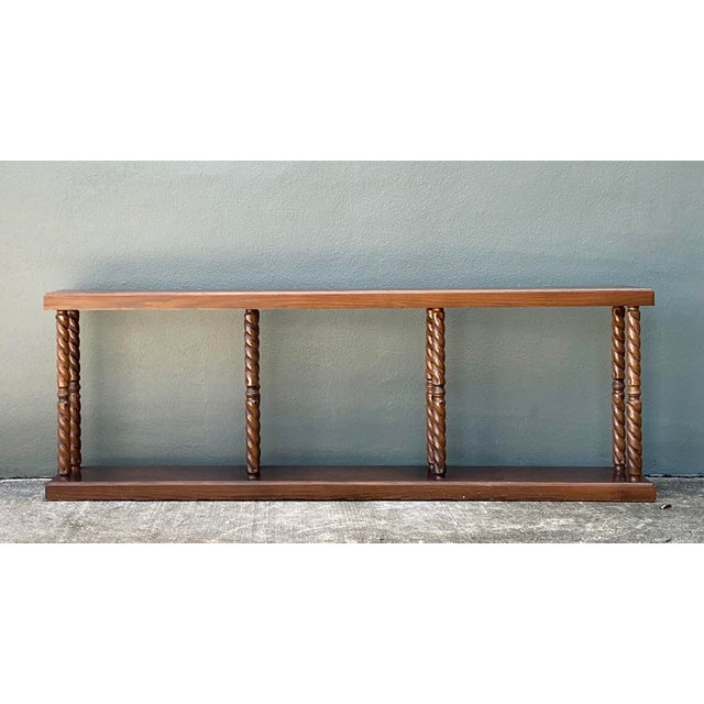This commanding vintage console table is a masterclass in architectural proportion and traditional craftsmanship. The...