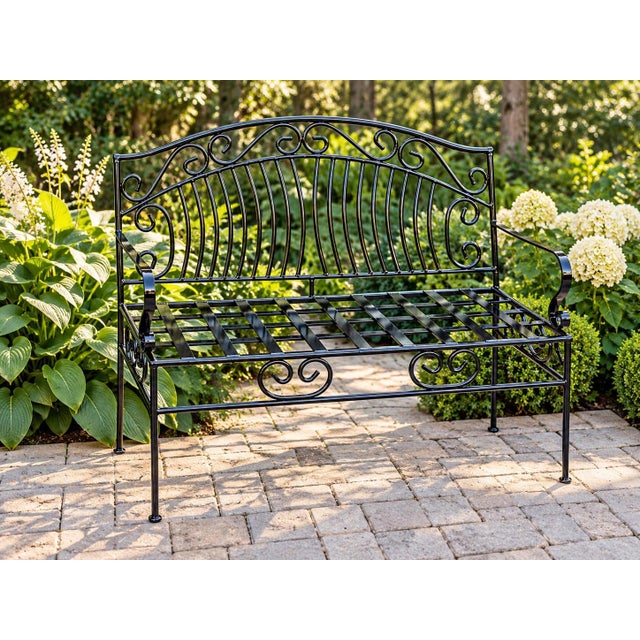 A charming vintage wrought iron garden bench featuring an elegantly arched back embellished with generous scrolling...
