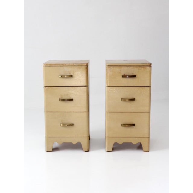 Vintage pair of late 1940s–1950s nightstands featuring softly rounded edges, a warm parchment-toned finish, and...