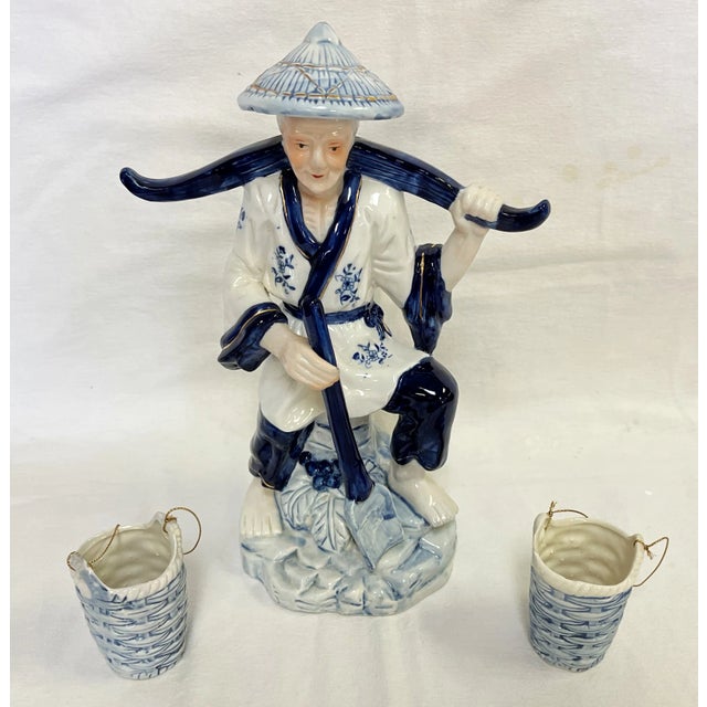 Sweet vintage Asian figurine carrying baskets. Made of ceramic porcelain, and finished in blue and white tones with...