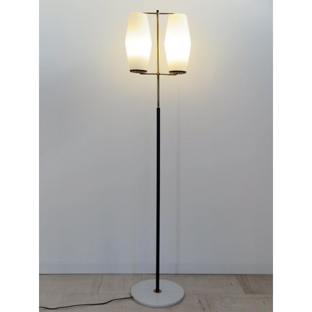 Italian midcentury modern design floor lamp produced by Stilnovo with metal and brass stem, white Carrara marble base, and...