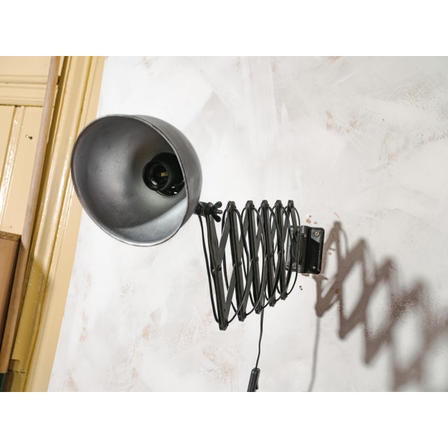 A black scissor wall lamp by adem, made in the netherlands, with an extendable harmonica mechanism. An original vintage...