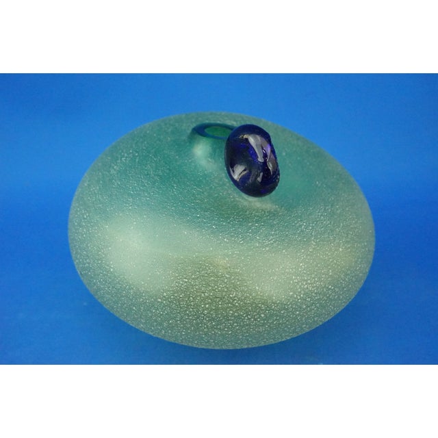 A wonderful globular vase in Murano glass, vaguely apple-shaped, green in color, darker on the mouth that slowly fades...