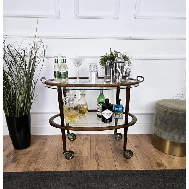 Unique and very elegant Italian Art Deco dry bar cabinet cart with two glass tiers and highlighted by the great wooden...