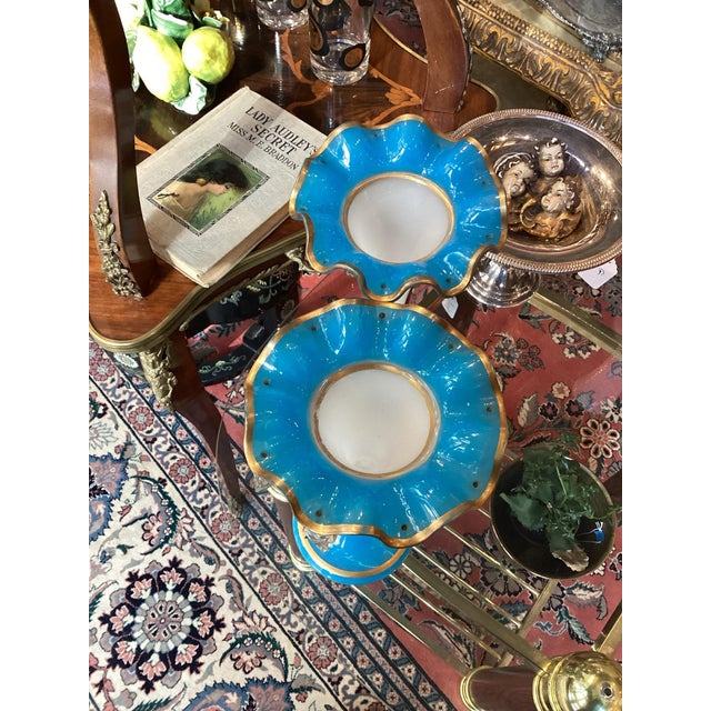 This is a charming pair of antique French Opaline glass vases in blue and white, with a delicate gold painted rime and...