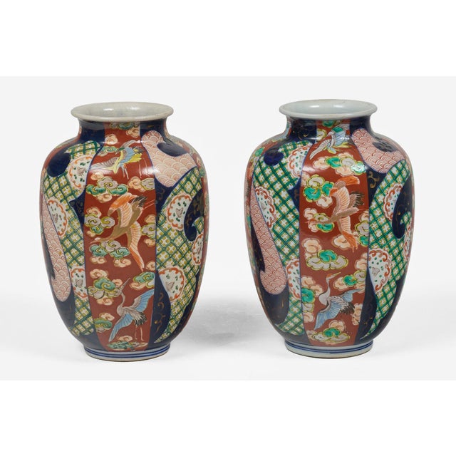 Antique pair Imari baluster shaped open vases with round flared necks tapering slightly at the base are decorated with six...