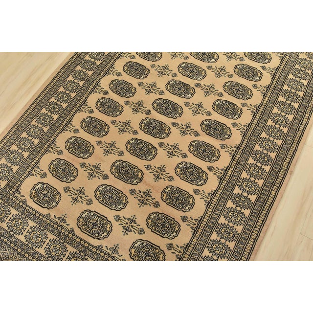 A tribal Bokhara rug hand-knotted with fine wool on a cotton foundation. This rug features rows of repeating medallions...