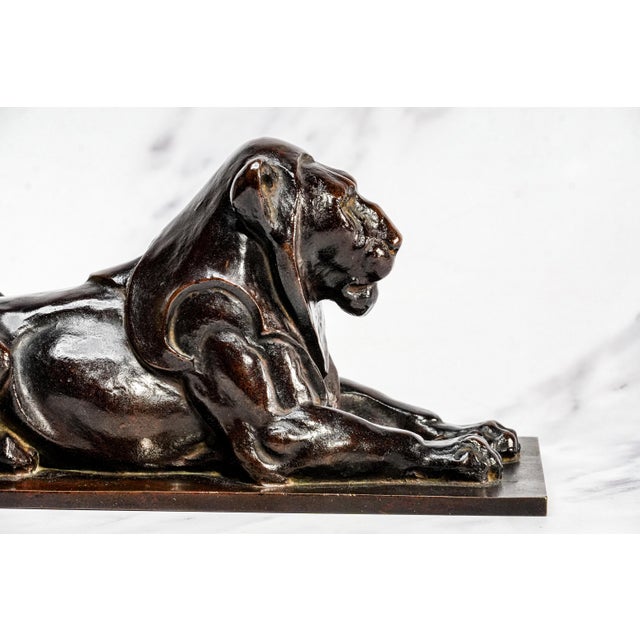 A striking example of early 20th-century decorative metalwork, this circa 1915 cast metal statue depicts a reclining lion,...