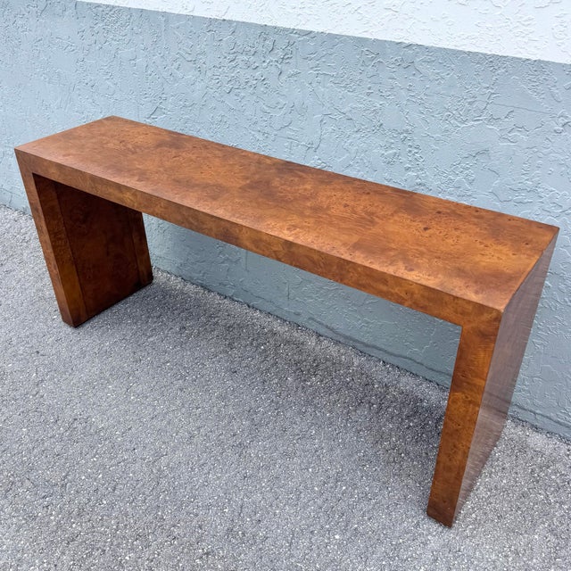 A refined study in form and material, this mid-century modern console table showcases the timeless beauty of burlwood in a...