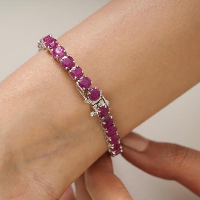 A classic ruby eternity-style tennis bracelet crafted in 925 sterling silver, defined by its continuous line of color and...