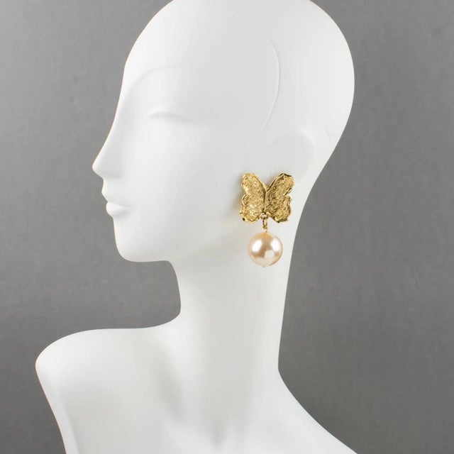 These elegant Guy Laroche Paris butterfly clip-on earrings feature an oversized, dangling shape with a carved and textured...