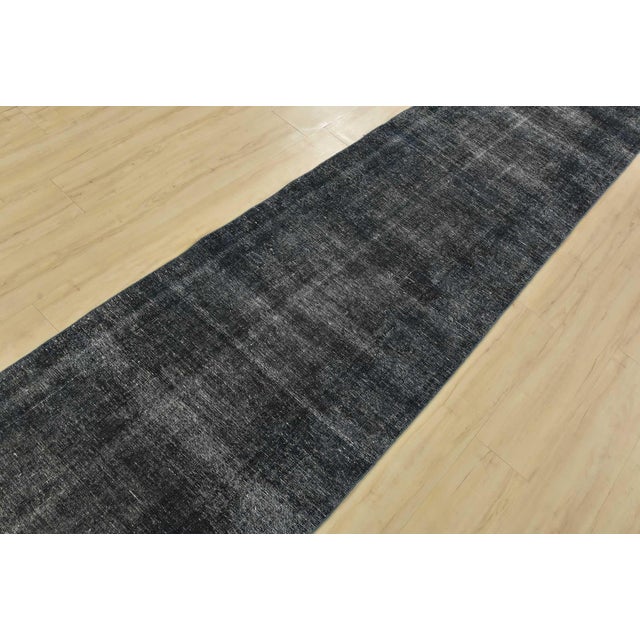 An authentic vintage overdyed Tabriz runner hand-knotted with fine wool on a cotton foundation. This rug features a solid...