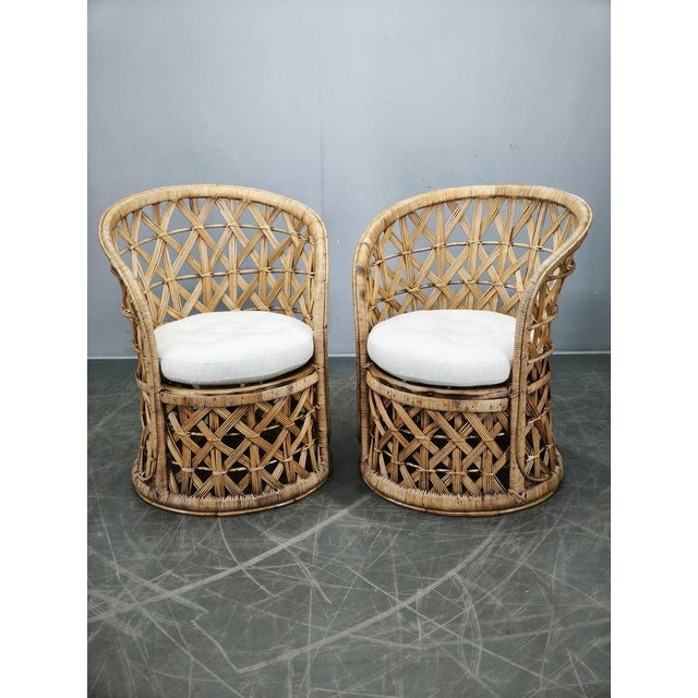 Exceptional pair of Italian bamboo and rattan lounge chairs dating from the 1960s. These highly decorative chairs feature...