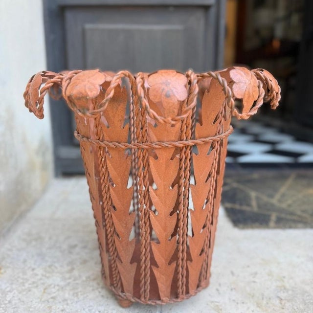 Sheet metal umbrella stand with a floral design, inspired by Art Nouveau. The flared, openwork structure combines twisted...