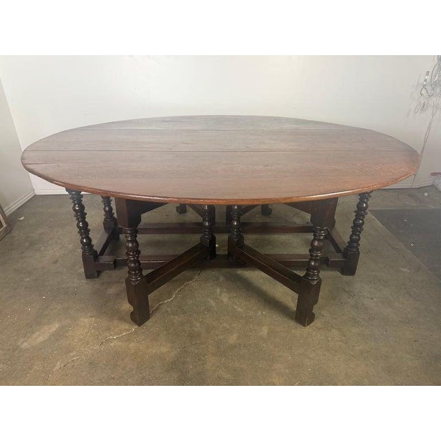 This handsome English gateleg dining table is crafted from richly grained oak and features a generous oval top supported...