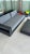 A confirmed Restoration Hardware outdoor pair: an architectural aluminum sofa with the signature open arm-shelf detail,...