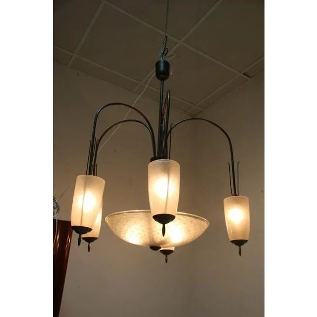 This chandelier was designed in the 1950s. It is made from burnished brass and Murano glass with air bubbles inside. The...