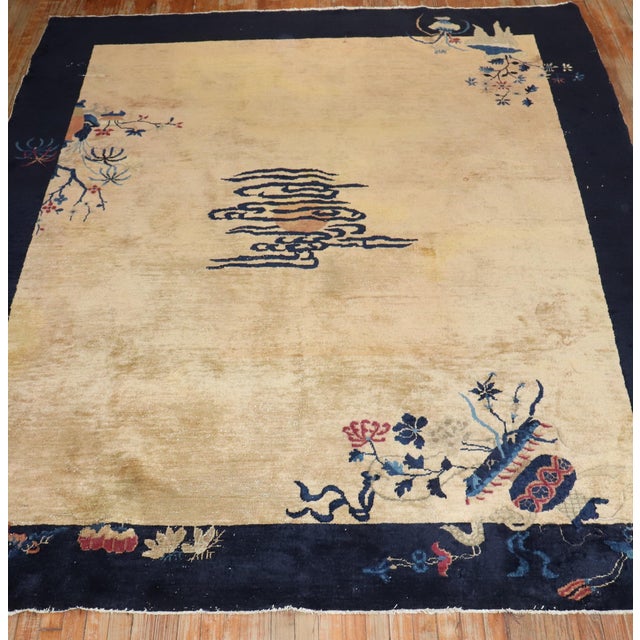 An authentic early-20th-century Chinese rug with a spacious open field floral design with an eclipsed medaion on a tan...