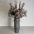 Handcrafted from richly toned grey marble, the Array Tall Vase is defined by its elongated silhouette and rhythmic carved...