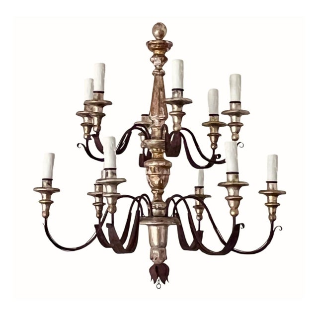 A beautifully scaled pair of 19th century Tuscan chandeliers, combining carved wood elements with hand-forged iron in a...