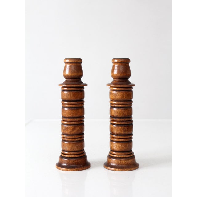Charming pair of vintage turned wood candlestick holders featuring eight removable center rings that can be stacked along...