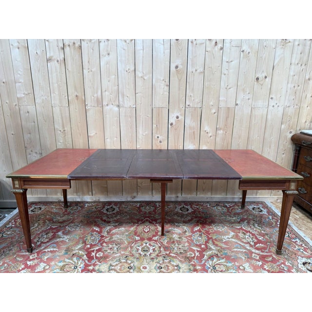 A square, extendable louis xvi style dining table, likely dating from the early 20th century, made of solid mahogany. the...