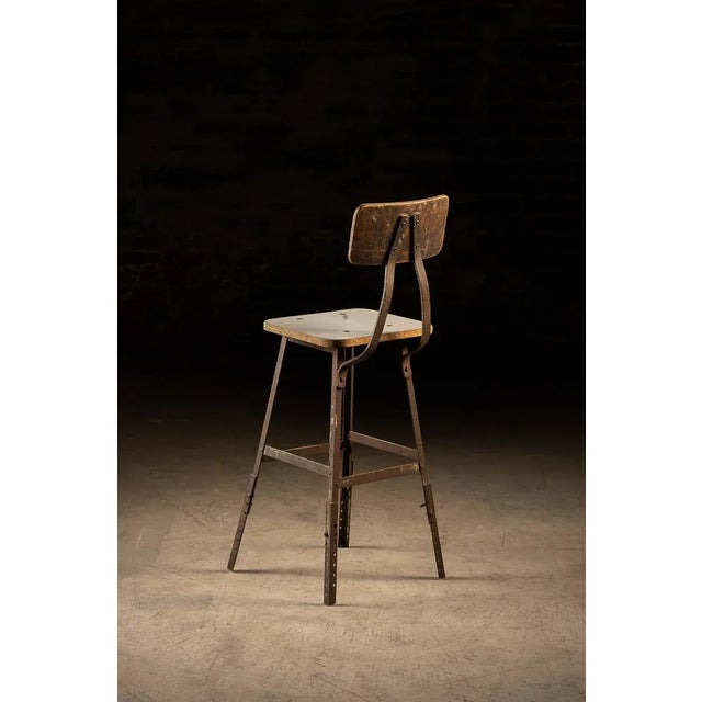 An industrial machinist stool with adjustable height. The screws are removed from the legs to adjust it up or down by a...