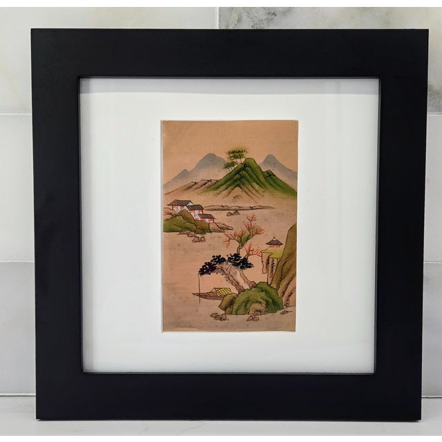 Chinese watercolor painting on silk depicting a serene mountain landscape dotted with village houses and graceful trees,...