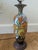 This table lamp features a base in the style of antique Dutch Gouda pottery from the 1920s, decorated with a vibrant,...
