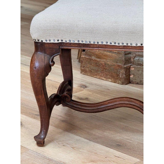 Fine Louis XIV-XV Stool, France, C. 1730. Walnut, recently upholstered in Belgian linen. 17½ h × 24 w × 19 d in (44 × 61 ×...