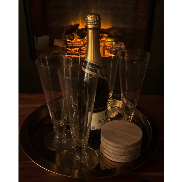 Set of five handmade mid-century clear glass champagne flutes with slender stems and subtle hand-blown variation.