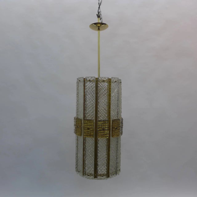 Over scaled Italian chandelier composed of textured glass slabs and brass striped with round textures glass circle at the...