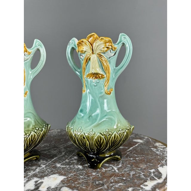 An elegant pair of glazed ceramic vases in the Art Nouveau style, dating from the late 19th to early 20th century. These...