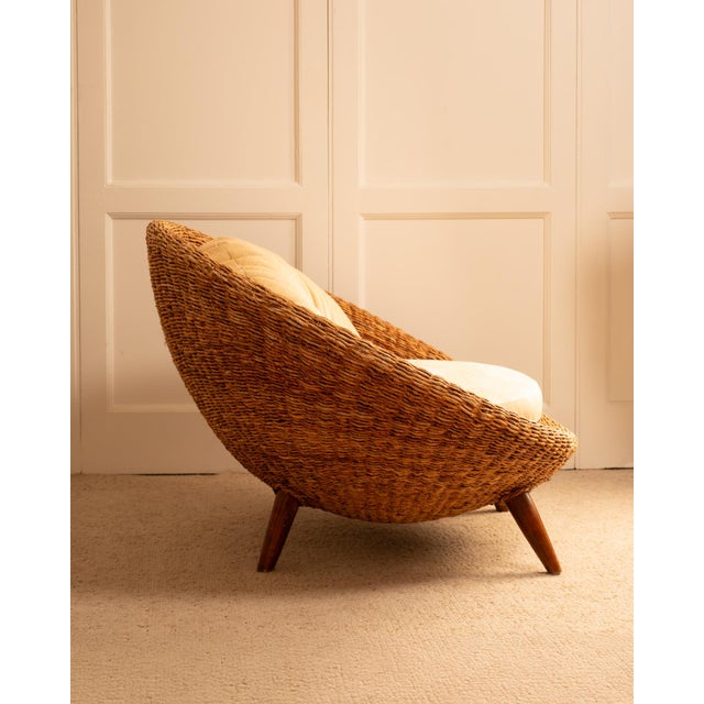A round rattan armchair from the 1970s. The croissant-shaped upholstered cushions invite relaxation. This wide armchair...
