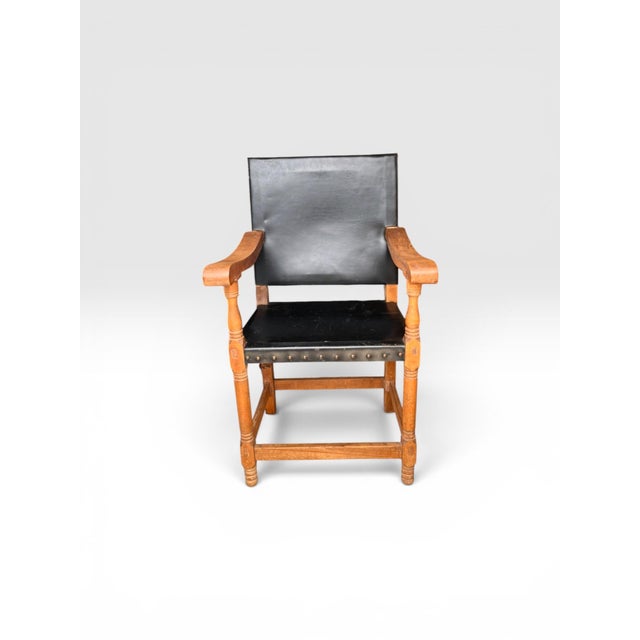 A handsome early 20th century arts and crafts, mission style armchair, featuring a solid oak frame with exposed Mortis -...