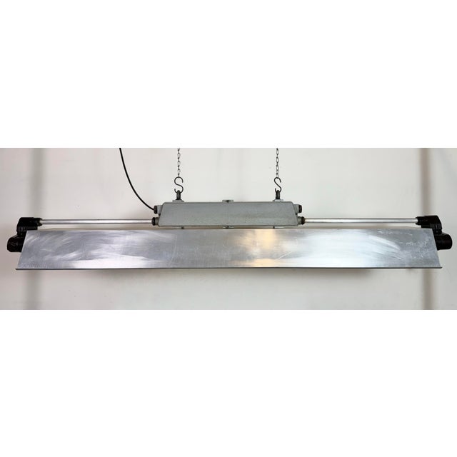 This industrial cast aluminium and bakelite light with aluminium shade was made by elektrosvit during the 1970s in former...