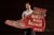 A monumental, boot-shaped wooden trade sign for Peerless Shoe Repair, painted in strong roadside red with white block...