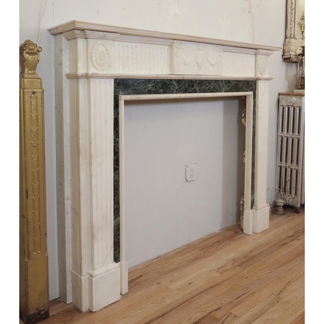 Regency style white statuary marble mantel with light gray veining and emerald green marble inlay framing the firebox. The...