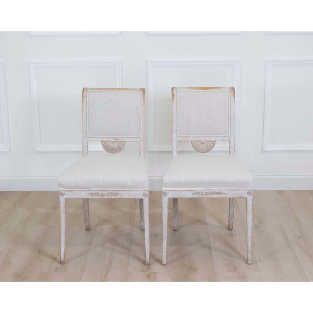 Elegant pair of Stockholm-made Gustavian chairs dating to approximately 1820. Featuring decorative plaster ornamentation,...