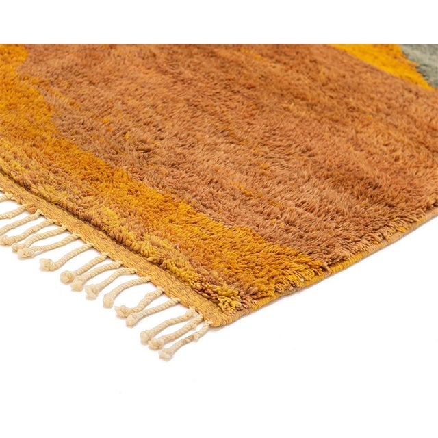 Striking hand-knotted wool rug featuring a captivating abstract design with a vibrant palette of Gold Ochre, Blue,...
